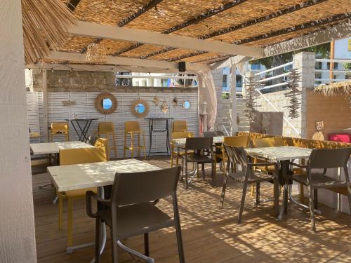 un restaurant avec des tables et des chaises dans une salle dans l'établissement Ajaccio centre bord de mer T3, à Ajaccio