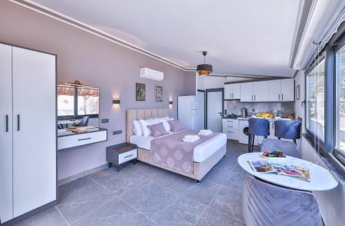 a bedroom with a bed and a table and a kitchen at White House Apart in Kaş