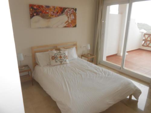 ミハス・コスタにあるApartment in Las Palmeras de Calahondaのベッドルーム(白いベッド1台、大きな窓付)