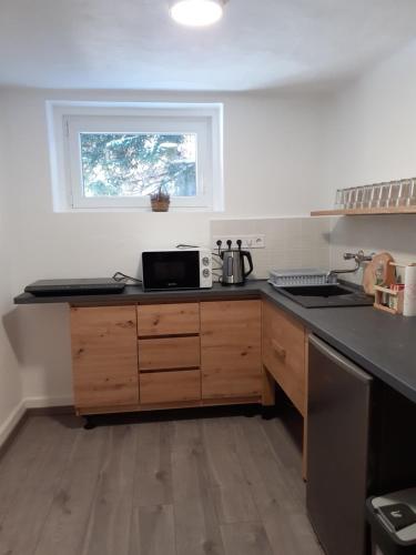 a kitchen with a counter top and a window at Mátrai5Vendégház in Galyatető