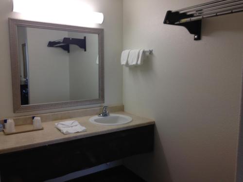 a bathroom with a sink and a mirror at America Inn & Suites in Ridgecrest