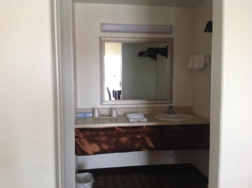 a bathroom with a sink and a mirror at America Inn & Suites in Ridgecrest