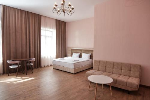 a bedroom with a bed and a couch and a table at KUMA Hotel Gyumri in Gyumri