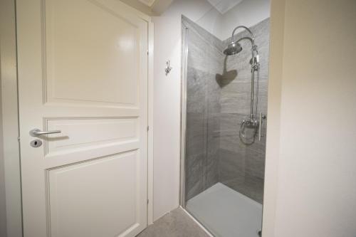 uma casa de banho com um chuveiro e uma porta de vidro em Bnbook Maison Charlotte Lago Maggiore em Porto Valtravaglia