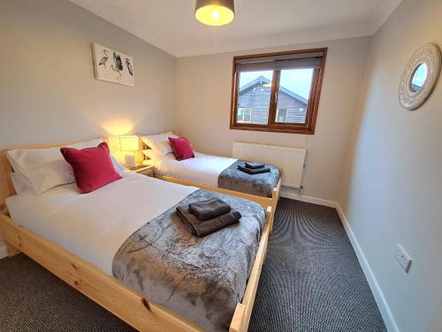 una camera con due letti e una finestra di River Rest - Norfolk Broads a Brundall