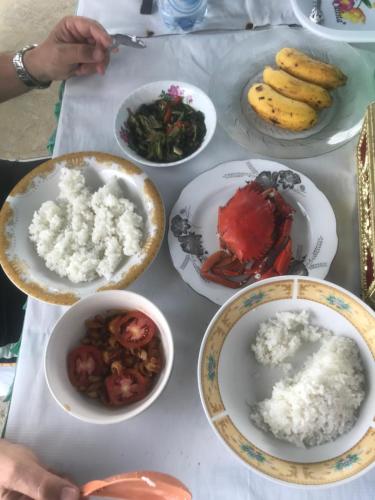 Hogarista Homestay في Kaledupa: طاولة عليها أطباق من الطعام
