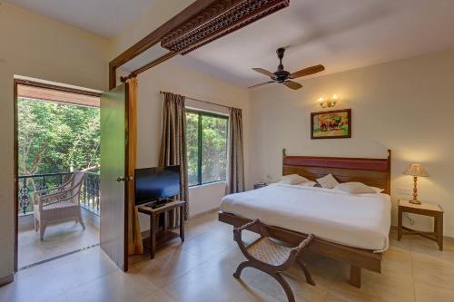 a bedroom with a bed and a balcony at Ramsukh Resorts and Spa in Mahabaleshwar