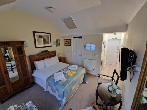 a bedroom with a bed and a tv and a chair at The Black Horse Inn in Canterbury