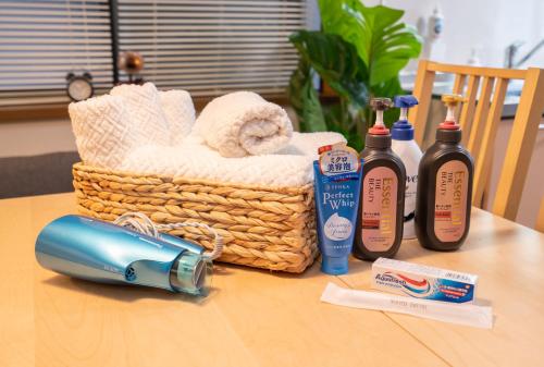 a table with a basket of towels and bottles of soap at Hanamikaku貸切一軒家4LDK新小岩駅徒歩5分電車で東京駅13分新宿駅30分ディズニーまで30分成田エクスプレスで65分直通 in Tokyo
