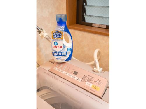 a bottle of laundry detergent sitting on top of a washing machine at Hanamikaku貸切一軒家4LDK新小岩駅徒歩5分電車で東京駅13分新宿駅30分ディズニーまで30分成田エクスプレスで65分直通 in Tokyo