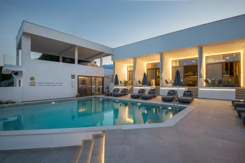 a house with a swimming pool in front of it at Akrotiri Olympus Luxury Suites - Adults Only in Plaka Litochorou