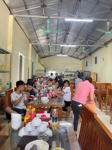 eine Gruppe von Menschen, die in einer Küche an Tischen sitzen in der Unterkunft Khách Sạn Hà Phương in Ninh Bình