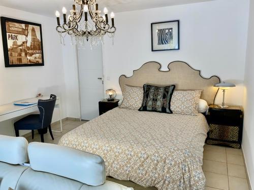 1 dormitorio con cama, escritorio y sofá en La Vie Est Belle En Provence, en Tourves