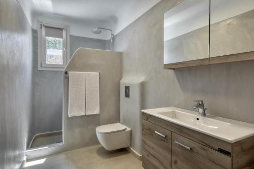 y baño con aseo y lavamanos. en Villa Cataleya 2 PRIVATE POOL, en Fanari