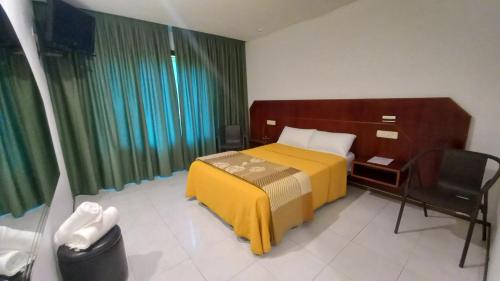 a hotel room with a bed and a chair at Motel Montecarlo in Teo