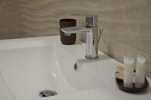 - un évier avec un robinet sur un comptoir blanc dans l'établissement Sea la vie casa vacanza, à Tarente