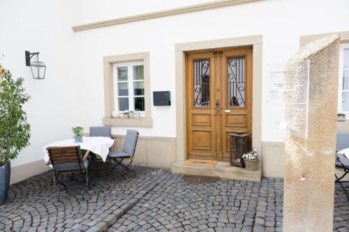 a patio with a table and chairs and a wooden door at Cabinett 1876 in Trittenheim