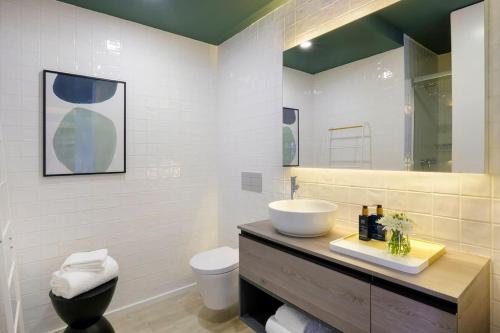La salle de bains est pourvue d'un lavabo, de toilettes et d'un miroir. dans l'établissement Retiro do Moliceiro, à Aveiro