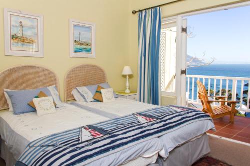 a bedroom with a bed with a view of the ocean at Albatross Guest House in Simonʼs Town