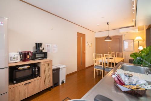 a kitchen with a sink and a microwave at Hanamikaku貸切一軒家4LDK新小岩駅徒歩5分電車で東京駅13分新宿駅30分ディズニーまで30分成田エクスプレスで65分直通 in Tokyo