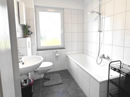 a white bathroom with a tub and a sink at # VAZ Apartments RS04 Küche, TV, WLAN, Balkon in Remscheid