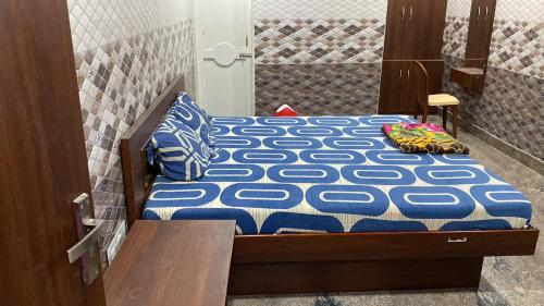 a bed with blue and white sheets and pillows on it at Sri Mahalakshmi Deluxe Lodging Arakonam in Arakkonam
