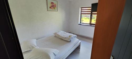 Cette chambre blanche dispose d'un lit et d'une fenêtre. dans l'établissement Guest house, à Târgu Jiu