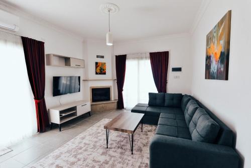 a living room with a green couch and a tv at Luxuriant Houses Kyrenia in Kérynia