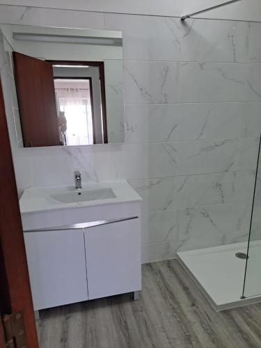 a white bathroom with a sink and a mirror at Sea, Sun and Wild Nature in Costa de Santo André