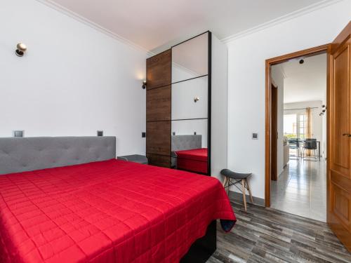 a bedroom with a red bed with a red blanket at Akisol Albufeira Water in Albufeira