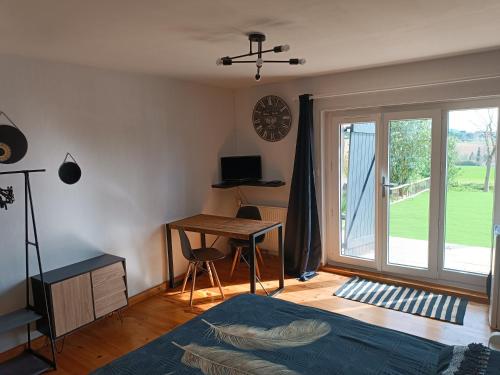 een slaapkamer met een bed, een bureau en een raam bij L'Eden in Tonneins