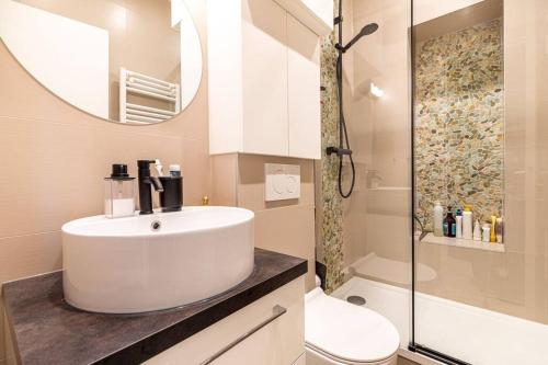 ein Badezimmer mit einem Waschbecken, einem WC und einem Spiegel in der Unterkunft GuestReady - Lovely urban retreat in the 17th Arr. in Paris