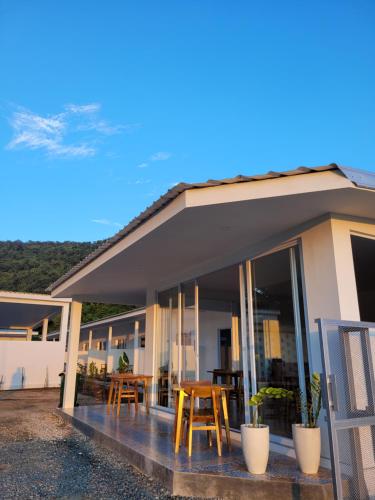 a house with a porch with chairs and tables at Kahurangi Hotel in Sekongkang