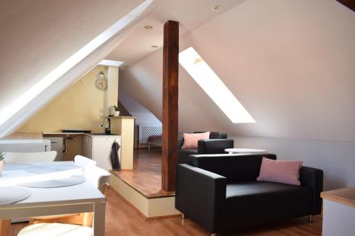 uma sala de estar com cadeiras pretas e uma escada em Apartament Starówka em Tuchola