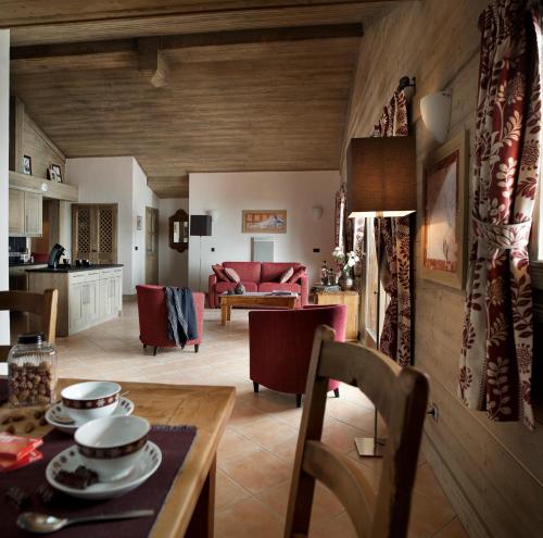 een keuken en een woonkamer met een tafel en stoelen bij CGH Résidences & Spas Le Télémark in Tignes