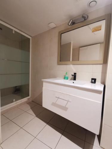 une salle de bain avec un lavabo blanc et un miroir dans l'établissement Appartement cosy centre de Nice, à Nice