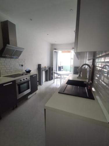 une cuisine avec un évier et une cuisinière four supérieur dans l'établissement Appartement cosy centre de Nice, à Nice