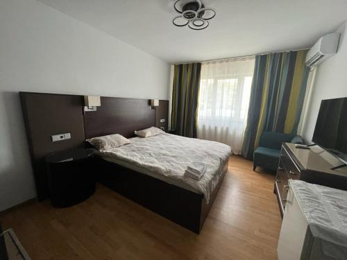um quarto de hotel com uma cama e uma televisão em Regim Hotelier Tecuci - Zona Industriala em Tecuci