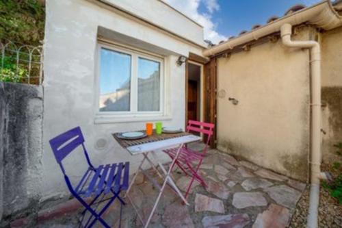 un patio con 2 sillas, una mesa y una ventana en Charming Studio of 17 m with garden Montpellier, en Montpellier