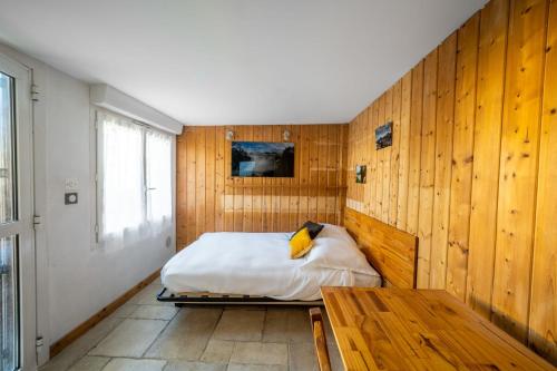 - une chambre avec un lit et un mur en bois dans l'établissement Charming Studio of 17 m with garden Montpellier, à Montpellier