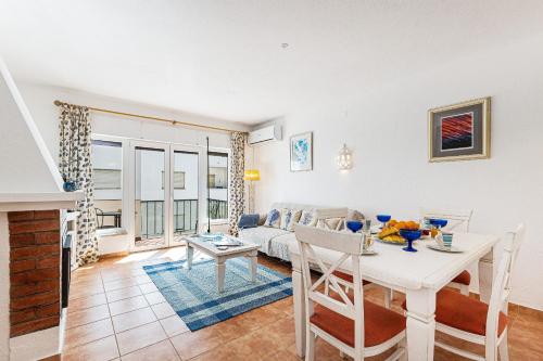 a living room with a table and a couch at Casa do Coral - Praia da Luz in Luz
