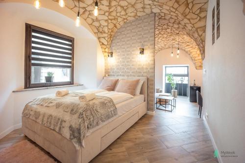 una camera da letto con un letto e un muro di mattoni di Apartament w Rynku I, MyWeek a Radków