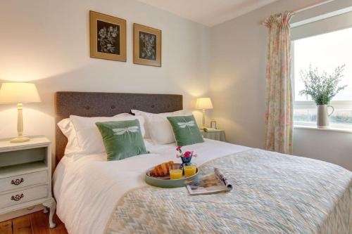 a bedroom with a bed with a bowl of fruit on it at No 1 Sparham Hall - Norfolk Cottage Agency in Necton