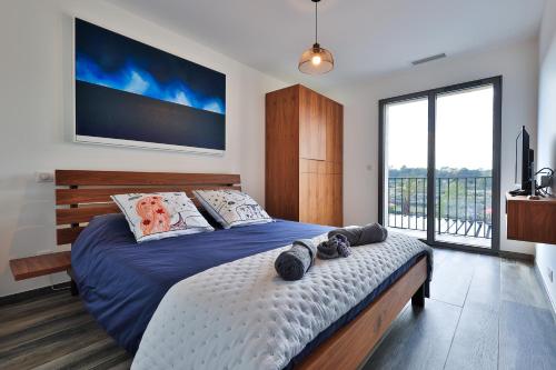 ein Schlafzimmer mit einem großen Bett und einem großen Fenster in der Unterkunft LES ROCHES DE BAUDISSET in Saint-Paul-en-Forêt