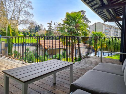 a wooden deck with a bench and a fence at Lyon Faubourg - Saint Priest in Saint-Priest