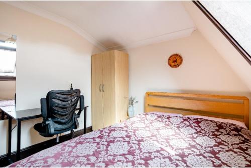 een slaapkamer met een bed, een bureau en een stoel bij Double room 2 mins from station in Belvedere