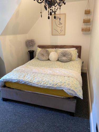 um quarto com uma cama com almofadas em Meadow View em Hurst