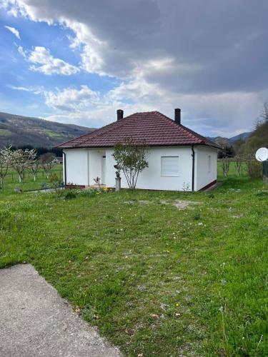 a white house with a grassy yard in front of it at Luxury House in Bijelo Polje