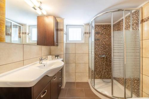 a bathroom with a sink and a shower at Captivating 2BR Apartment in Chalandri by UPSTREET in Athens