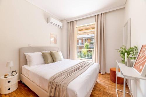 Un dormitorio blanco con una cama grande y una ventana en Captivating 2BR Apartment in Chalandri by UPSTREET, en Atenas